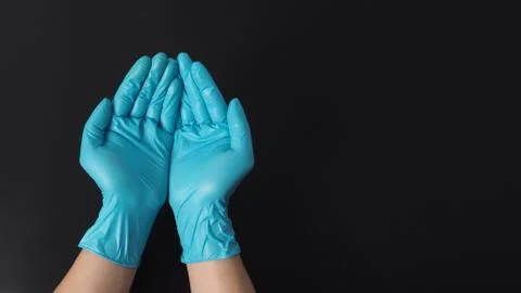 Two hand with gloves doing sign for beg or help on black background. Stock Photos