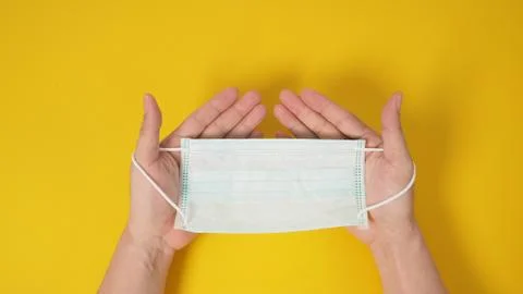 Two Hand holding back of face Mask or surgical mask for protection from virus Foto stock