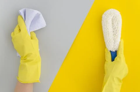 Two hand holds sponge for dusting, for washing bottles on yellow grey bright Stock Photos