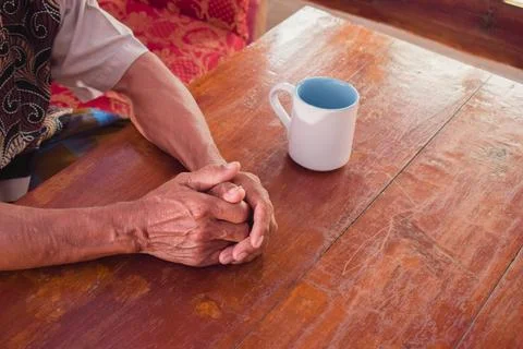 Two hand of senior elder on table, loneliness old man in living room with his Stock Photos