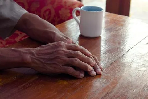 Two hand of senior elder on table, loneliness old man in living room with his Stock Photos
