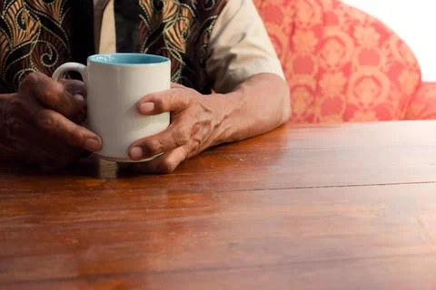 Two hand of senior elder on table, loneliness old man in living room with his Foto stock