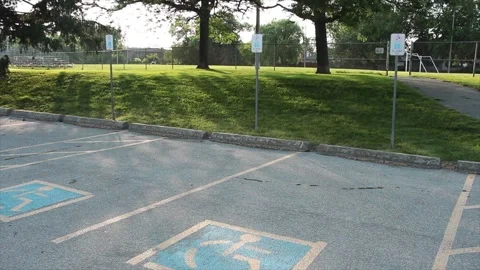 Two handicap parking spots with blue and yellow handicap logo inside them Video stock 246137214