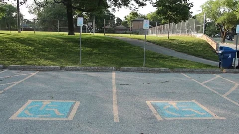 Two handicap parking spots with blue and yellow handicap logo inside them Stock Footage 246137231
