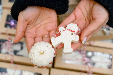 Two handmade candles in the shape of a gingerbread man and a pumpkin Stock Photos