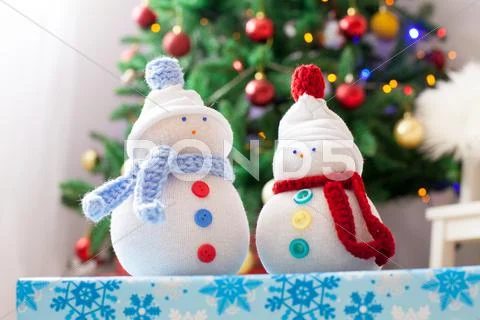 Two handmade snowmen with Christmas background on white fur Stock Photos