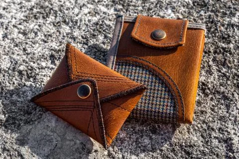 Two handmade wallets of brown leather on stone background. Fashion accessory. Stock Photos