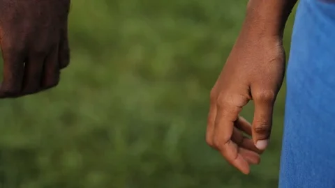 Two hands of African young people on green background. Hands of couple in love Stock Footage 81839774
