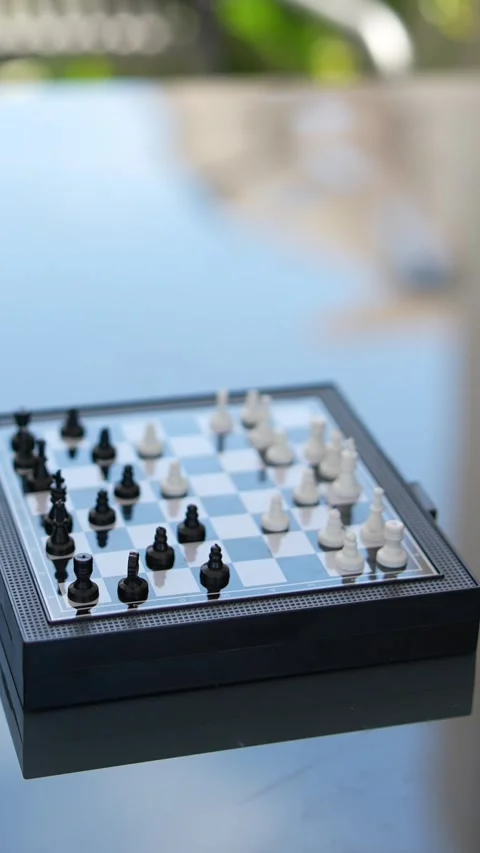 Two hands are actively engaged in a smallscale chess match on a tiny chessboard Stock Footage 278181445
