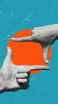 Two hands are positioned to form a frame around a bold orange circle set agai Stockfoto's