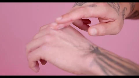 Two hands are shown in the image, one massaging the cream on the other, which is Stock Footage 269136787