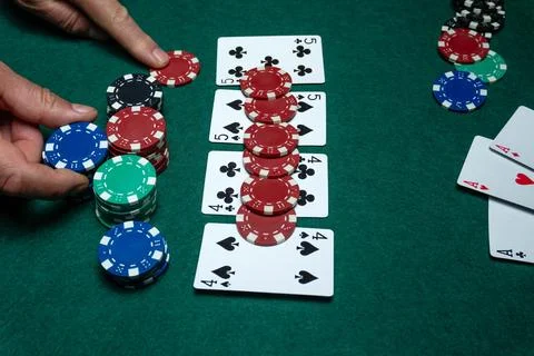 Two hands are shown placing poker chips on a green felt table. Five playing.. Stock Photos