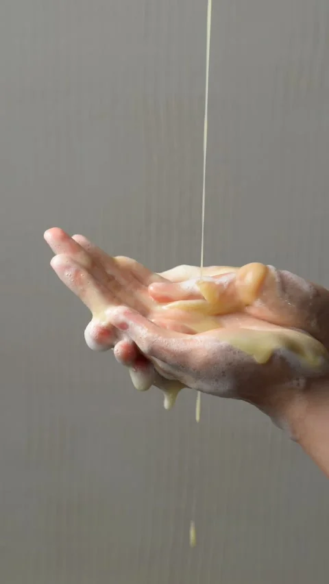 Two hands are shown washing with flowing soap, highlighting a key practice .. Stock Footage 304213169