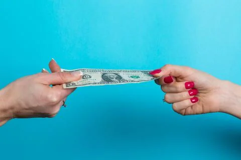 Two hands are stretching one dollar banknote pulling in each direction; harsh Stock Photos
