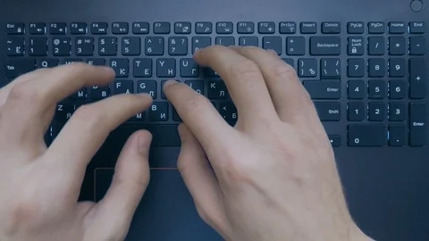 Two hands are typing on a laptop keyboard, top view, slow motion Stock Footage 103342907