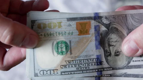 Two hands checking paper currency indoors with abstract background Vidéo 332122954
