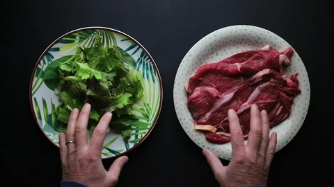 Two hands in choosing between a plate of salad or meat Stock Footage 127192843
