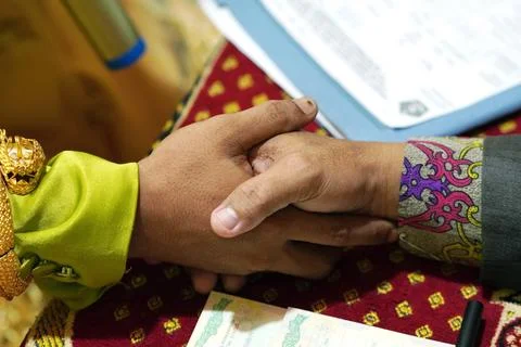 Two hands clasped together, symbolizing commitment and partnership during a.. Stock Photos