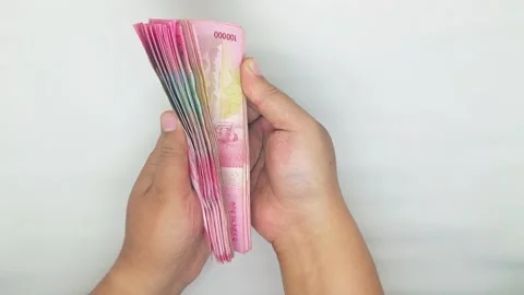 Two hands counting Indonesian banknotes in the 100000 rupiah denomination 스톡 동영상 302318962
