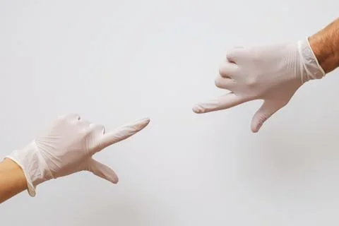 Two hands covered with rubber gloves reaching towards each other Stock Photos