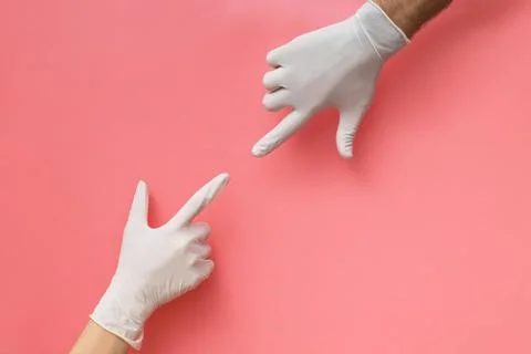 Two hands covered with rubber gloves reaching towards each other Stock Photos