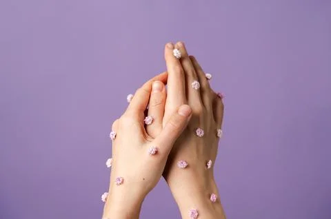 Two hands covered by small flowers holding each other Stock Photos