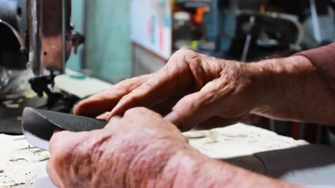 Two hands cutting a piece of leather with scissors Stock Footage 304713900