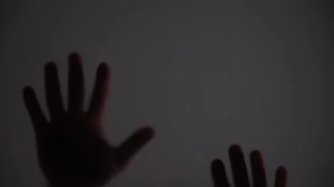 Two hands in a dark room, with the fingers spread apart Stock Footage 304286494
