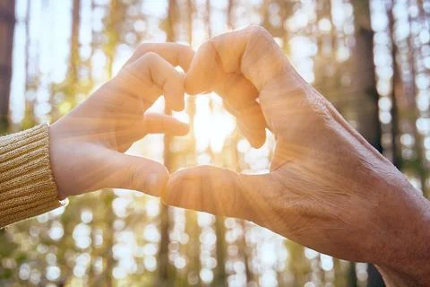 Two hands of different ages show a symbol of the heart. The background has Stock Photos