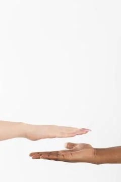 Two hands of different color placed right above each other, one African and the 写真素材