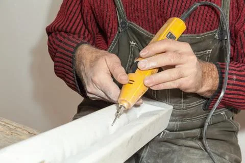 Two hands engraving marble with electrical engraver Stock Photos