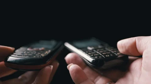 Two Hands Exchanging Mobile Phones in a Modern Digital Device Interaction for Stock Footage 312014398