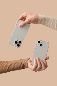 Two hands exchanging modern smartphones, digital communication and technology Stock Photos