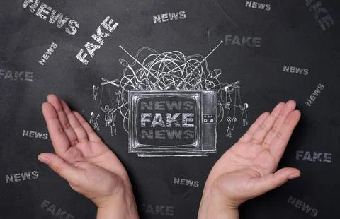 Two hands in front of a drawing of a TV with the inscription FAKE NEWS, pup.. Stock Photos