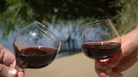 Two hands with glasses of wine clink glasses in slow motion Stock Footage 134835714