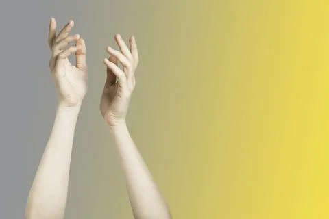 Two hands on the gray and illuminating yellow background Stock Photos