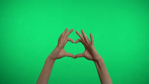 Two hands on a green background represent a heart. Video stock 163599870
