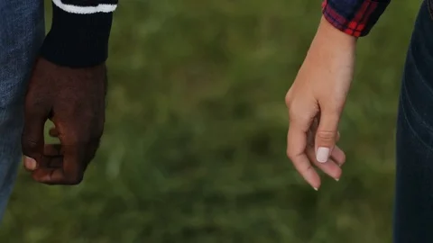 Two hands of guy and girl on green background. Hands of couple in love against Stock Footage 81839906