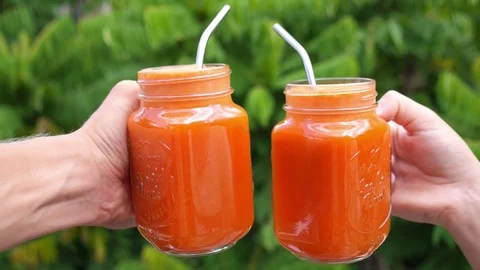 Two Hands with Healthy Carrot Juice in Glass Jar Stock Footage