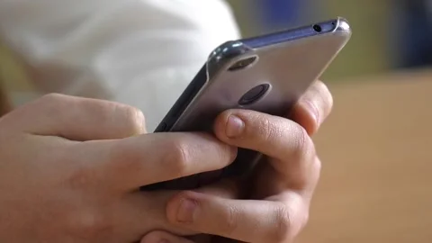 Two hands hold a blue smartphone and play games Stock-Footage 130047673