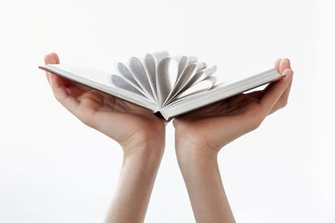 Two hands hold an open book on a white background. The concept of learning, s Stock Photos