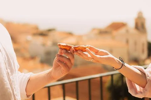 Two hands hold pastry while showing city in background during daylight hours  Stock Photos