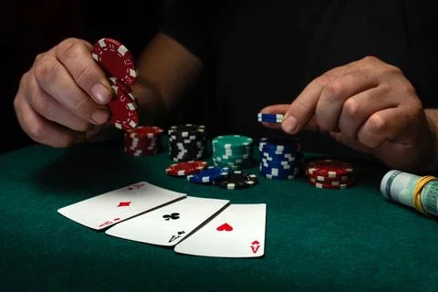 Two hands hold poker chips of different colors while three cards lay face u.. Stock Photos