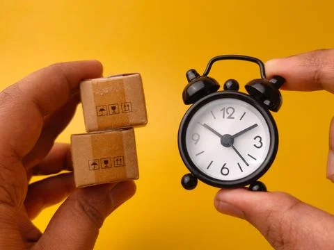 Two hands hold a stack of two small brown cardboard boxes alongside a black.. Stock Photos