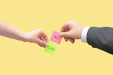 Two hands hold two sticky notes with the words We Can Stock Photos