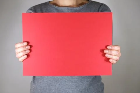 Two hands holding blank red paper sheet 库存照片