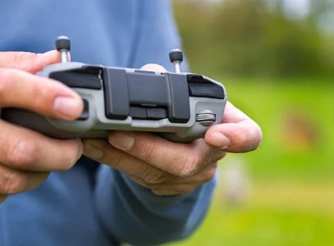 Two hands holding a drone remote controller while adjusting camera wheel 写真素材