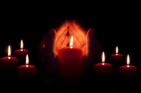 Two hands illuminated by  a candle Stock Photos