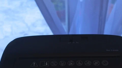 Two hands insert a document into a full shredder Stock Footage 125434954