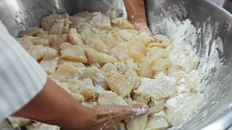 Two hands kneading and mixing raw fish pieces with flour. Stock Footage 342517140